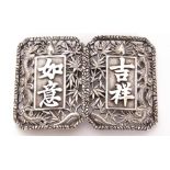 Pair of Chinese white metal buckles decorated with pierced foliage and dragon detail, marks to