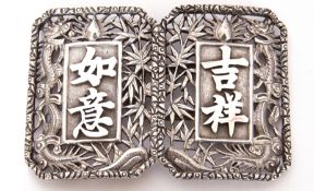 Pair of Chinese white metal buckles decorated with pierced foliage and dragon detail, marks to