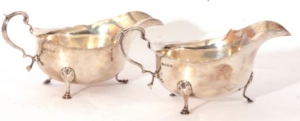 Pair of George V silver sauce boats fitted with looped handles and raised on small hoof feet,