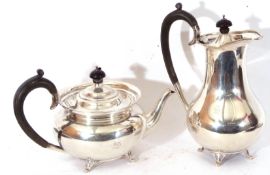 George V silver tea pot of squat form fitted with hinged lid with ebonised finial and a scrolling