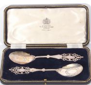 George V cased pair of presentation silver spoons with elegant pierced finials and decorated