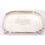 George VI silver card tray with shaped border raised on short swept legs, bearing presentation