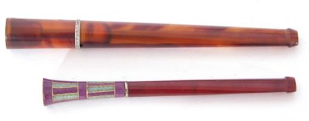 Mixed Lot: two long stemmed amber cheroot holders, one decorated with a coloured enamel end with