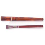 Mixed Lot: two long stemmed amber cheroot holders, one decorated with a coloured enamel end with