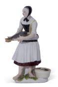 Large mid-18th century Meissen figure of a fish seller holding a fish with basket of fish beside