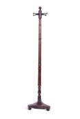 Regency mahogany cloak stand with a ring turned column to a triple splayed base, ball finial and