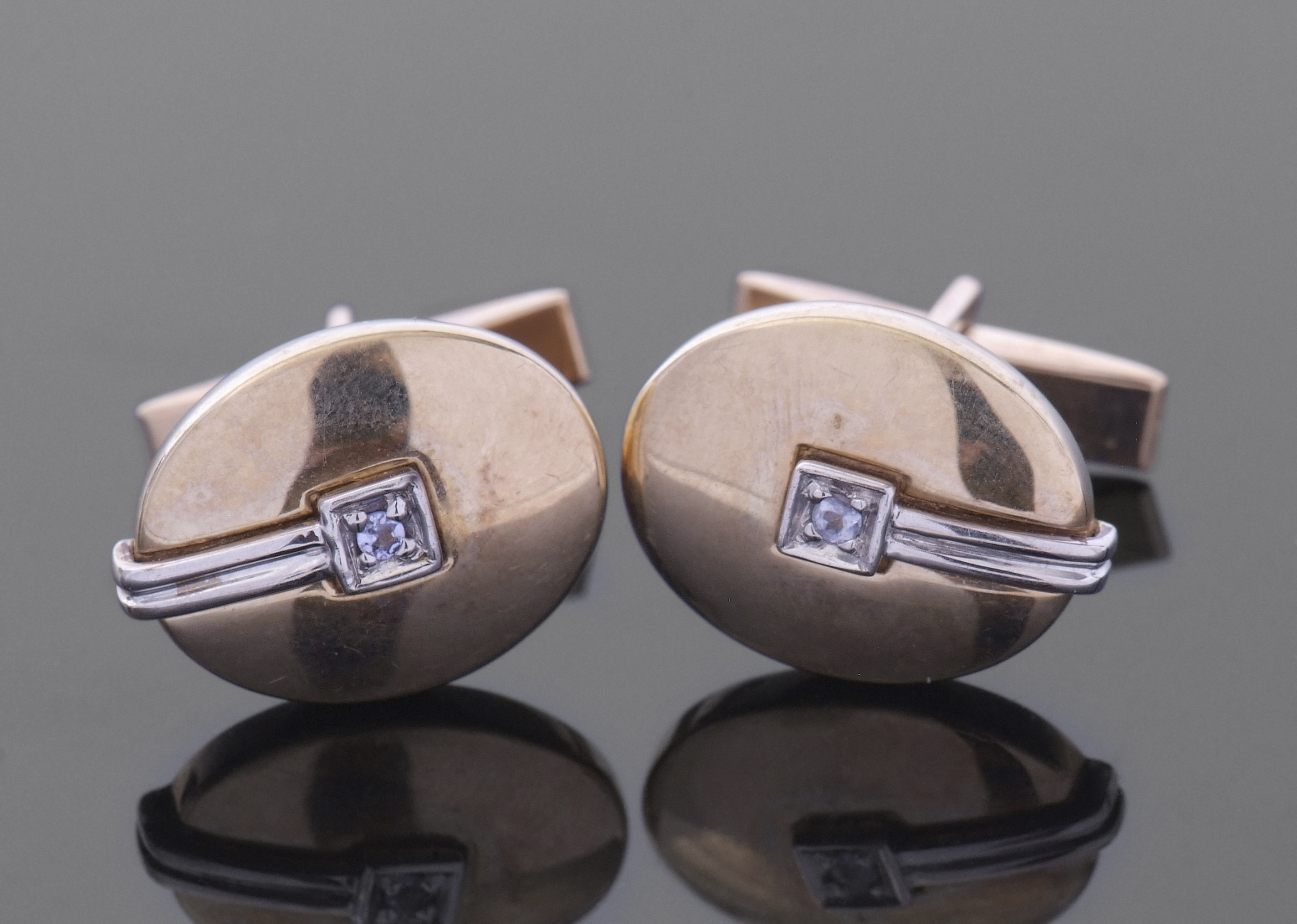Pair of 9ct two-tone gold cuff links of polished oval domed form, each highlighted with a small