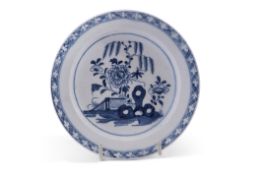 Small Lowestoft plate or stand painted in underglaze blue with a fence and flowering plants design
