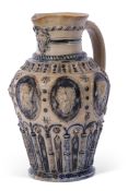 T Smith & Co Art pottery mask jug, the buff body decorated with heads in Gothic style above