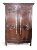 19th century French Oak armoire with carved detail to frieze and panelled doors, the doors with