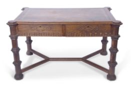 Late Victorian Gothic style oak writing table, the two drawers and frieze applied with a Gothic