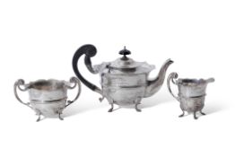 Edwardian three piece silver tea set of circular form with card cut rims, flying scroll handles,