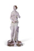 Continental porcelain figure of a classical lady seated on a stump holding a sheaf of corn, possibly