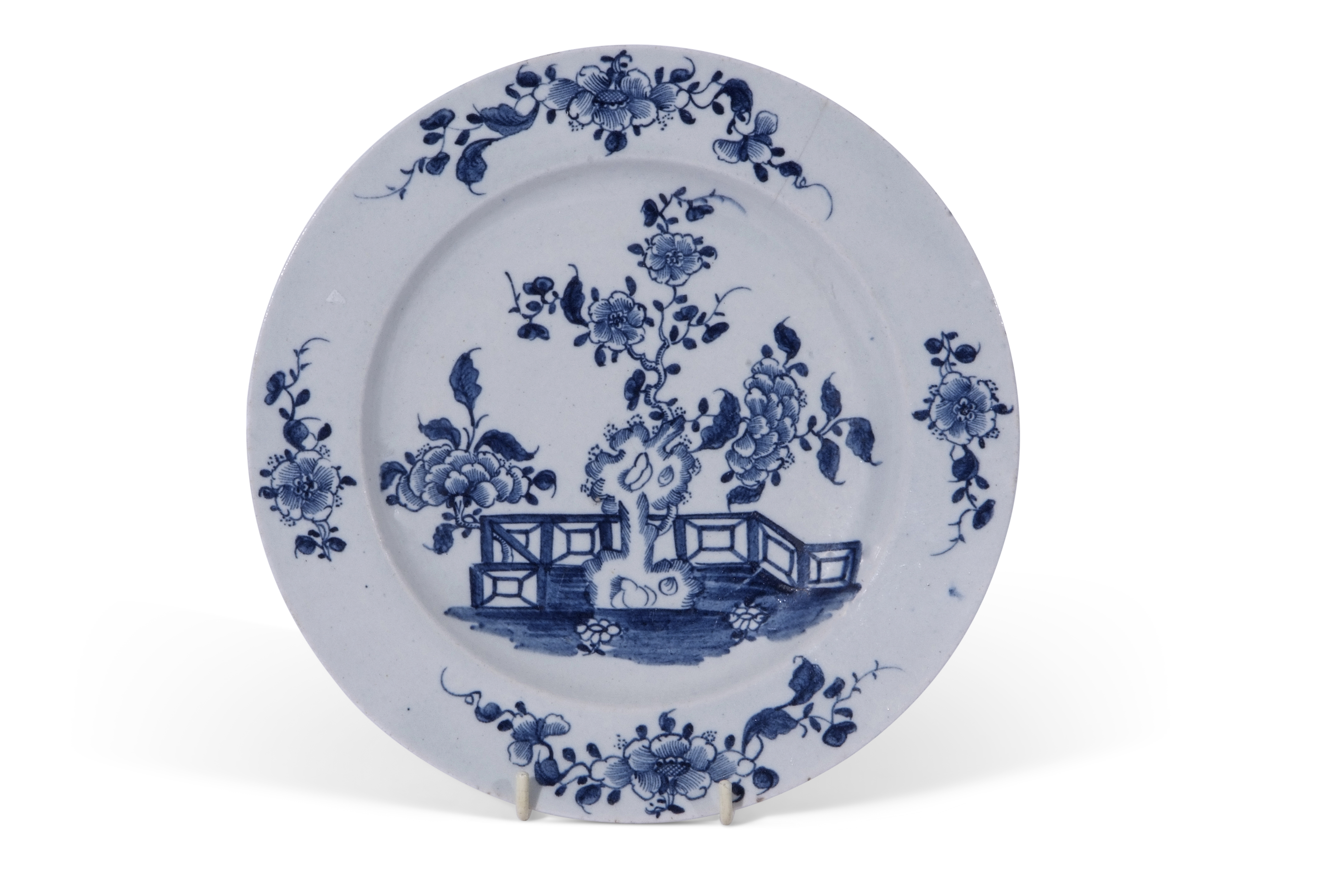 Lowestoft plate decorated in underglaze blue with a fence and flowering plants, 23cm diam (