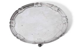 George V silver salver of circular form with indented detail to the rim, plain centre, raised on