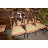 SET OF SIX LATE VICTORIAN OAK FRAMED DINING CHAIRS, THE BACKS CARVED WITH STYLISED FLORAL DETAIL