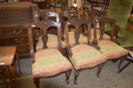 SET OF SIX LATE VICTORIAN OAK FRAMED DINING CHAIRS, THE BACKS CARVED WITH STYLISED FLORAL DETAIL