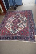20TH CENTURY CAUCASIAN WOOL FLOOR RUG WITH LARGE CENTRAL MEDALLION ON RED, CREAM AND BLUE GROUND,