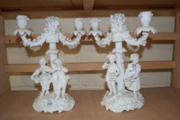 PAIR OF BLANC DE CHINE CANDELABRA DECORATED WITH FIGURAL BASES AND FLORAL DETAIL, 27CM HIGH