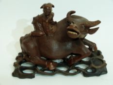 Oriental carving of a boy on a buffalo on wooden base, 20cm long