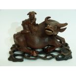 Oriental carving of a boy on a buffalo on wooden base, 20cm long