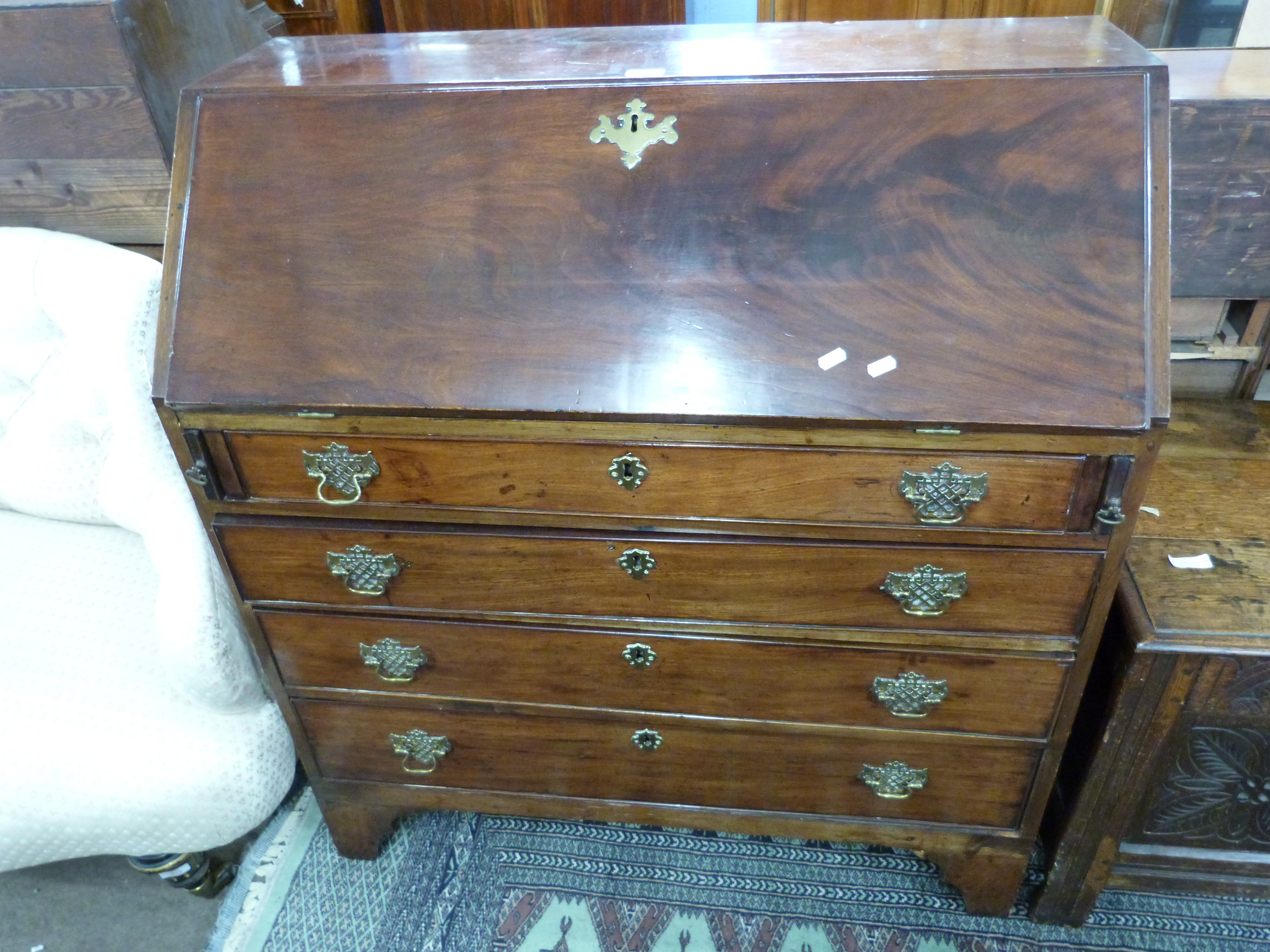 George III mahogany bureau with fall front opening to a fitted interior over three long drawers