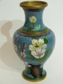 Cloisonne vase decorated in typical fashion with flowers on blue and gilt ground, 23cm high