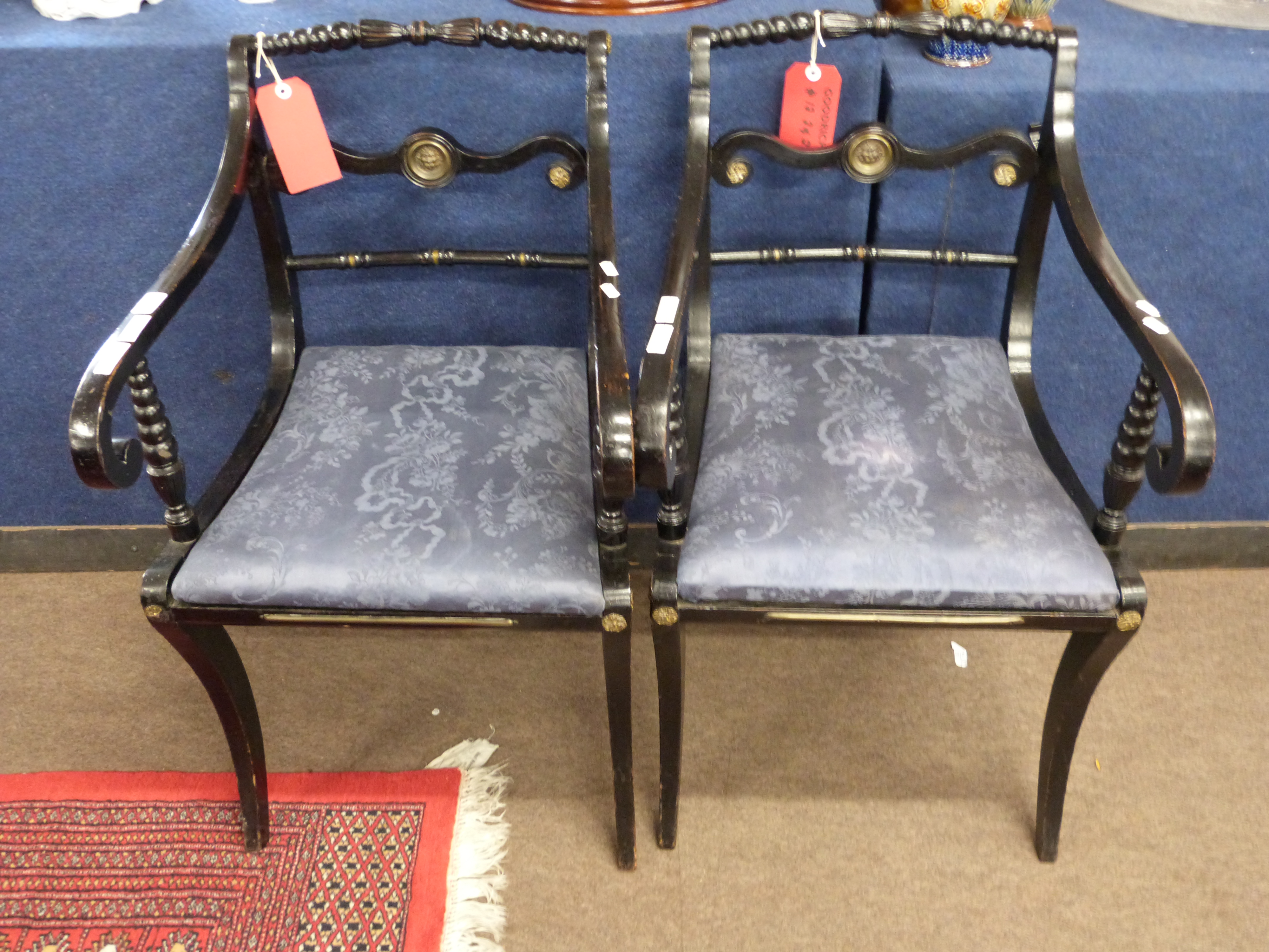 Pair of Regency ebonised and brass mounted side chairs with scrolled arms, cabriole legs and