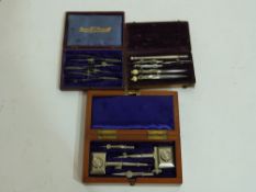 Three antique small cased drawing instrument sets, to include bridge compasses, dividers etc,