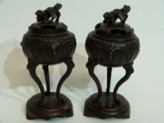 Pair of Oriental censers on oval stands, the censers raised on three elongated feet, the covers with