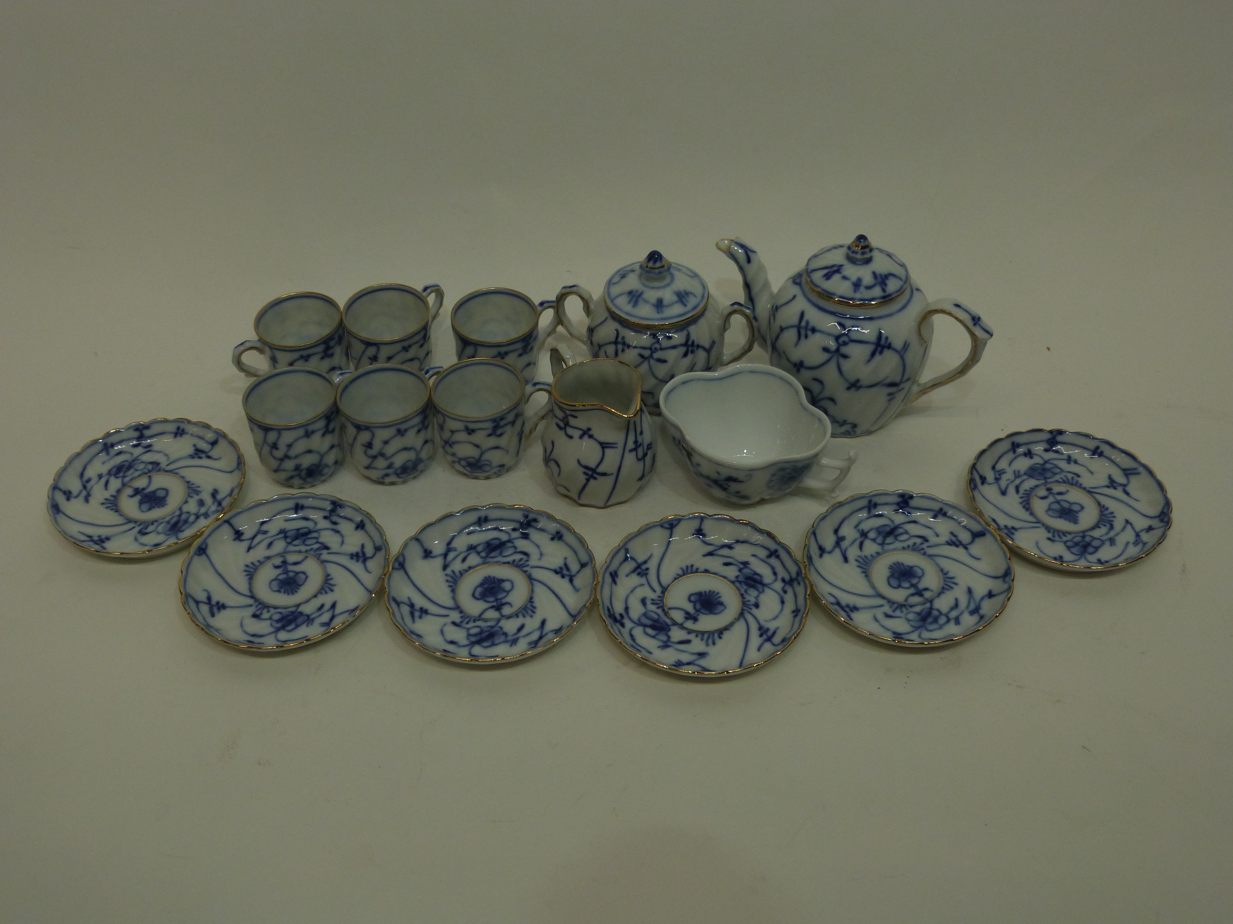 Miniature tea set with a blue design in Meissen style comprising small tea pot, sucrier and cover,