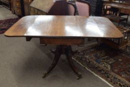 George IV mahogany drop leaf pedestal dining table set on turned column with four swept legs with