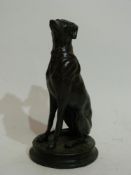 Bronze effect model of a dog seated on its haunches on circular base, the base impressed "Barye"