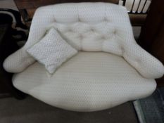 Late 19th century small sofa of unusual form, upholstered in pale floral decorated fabric, raised on