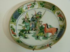 Famille vert Chinese porcelain dish decorated with warriors and horses to the centre within floral