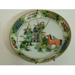 Famille vert Chinese porcelain dish decorated with warriors and horses to the centre within floral