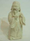 Unusual white pottery glazed figure of a Chinese deity, 15cm high