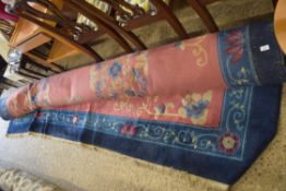 LARGE CHINESE WOOL FLOOR RUG DECORATED WITH FLOWERS AND STYLISED DETAIL ON A RED AND BLUE