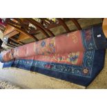 LARGE CHINESE WOOL FLOOR RUG DECORATED WITH FLOWERS AND STYLISED DETAIL ON A RED AND BLUE