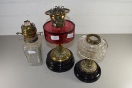 VICTORIAN OIL LAMP BASE WITH CRANBERRY GLASS FONT TOGETHER WITH TWO FURTHER OIL LAMP BASES