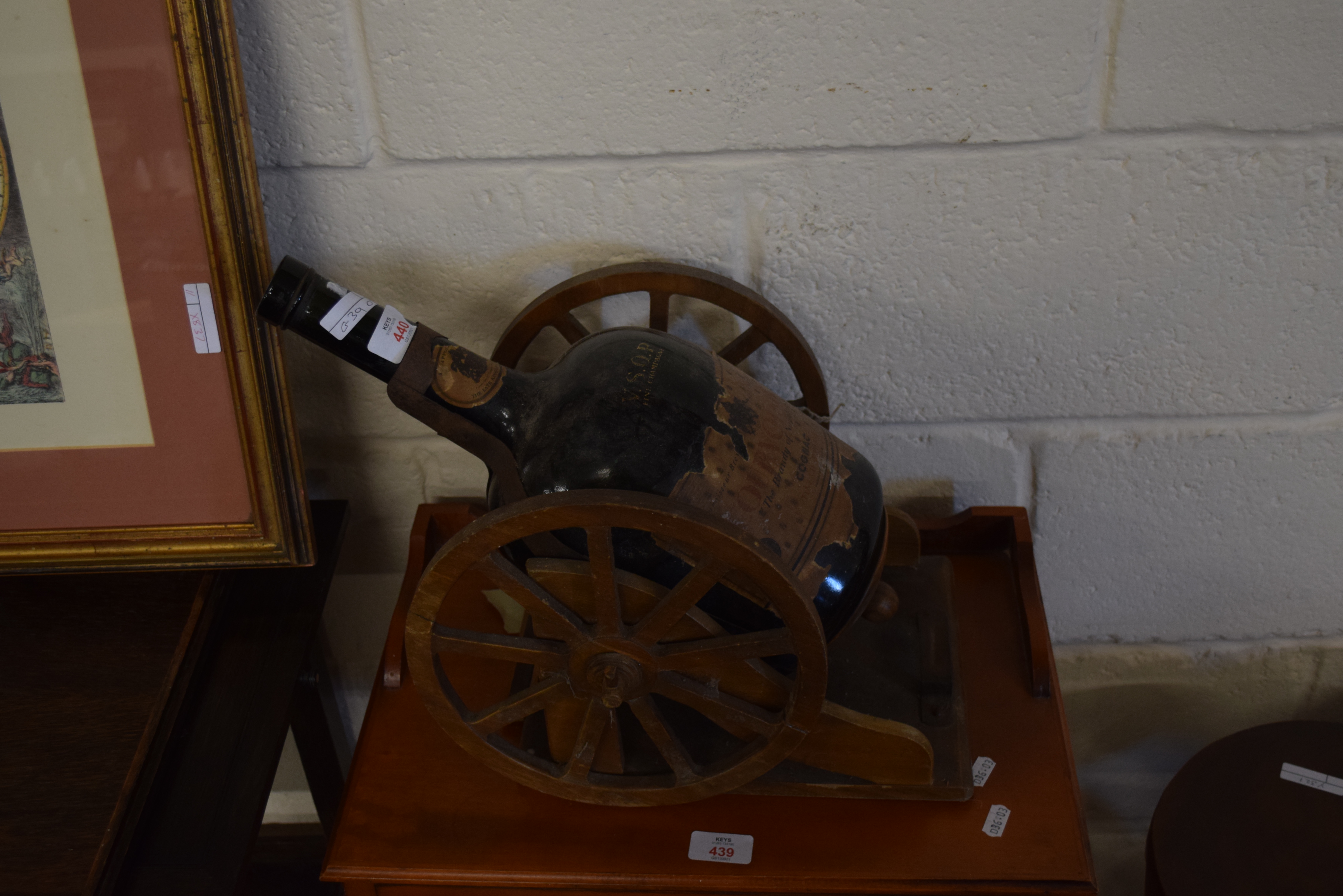 EMPTY BOTTLE OF COURVOISIER COGNAC MOUNTED ON A WHEELED BASE, 50CM LONG