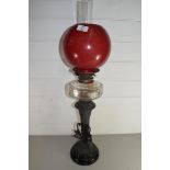 VICTORIAN OIL LAMP WITH RED GLASS SHADE, CLEAR GLASS FONT AND METAL STEM