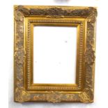 A gilt picture frame in decorated shell and foliate. Approx 27x21in inches.