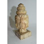 Oriental carved stone figure of heads of deities on square mount, (4)