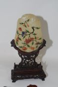 Piece of quartz with floral green decoration on Chinese wooden stand