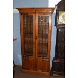 Late 19th century light oak bookcase cabinet, with two large lead glazed doors with Art Nouveau