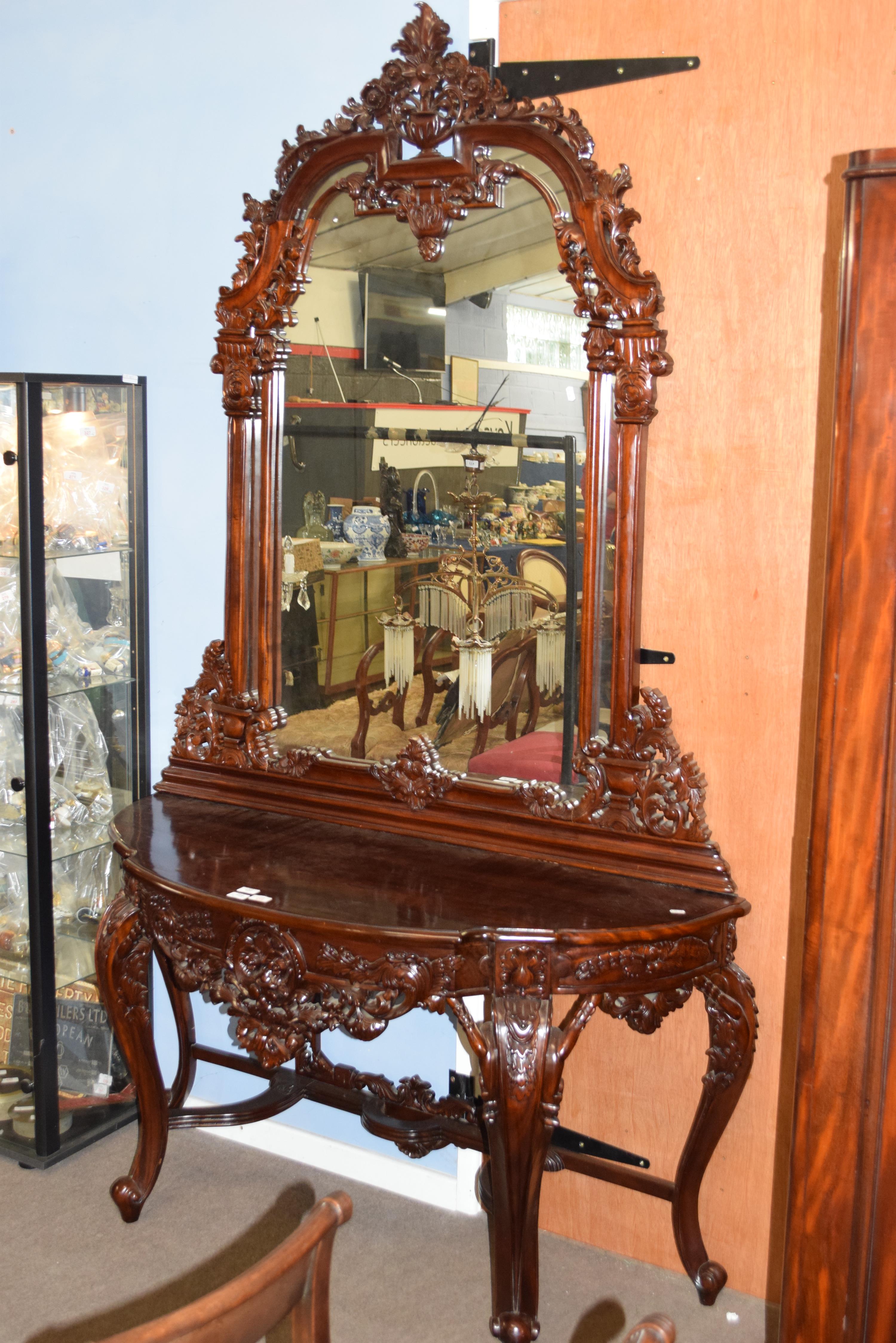 20th century hardwood demi-lune hall table with mirror back, extensively carved with foliate detail,