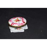 Small 19th century oval enamel pill or patch box decorated with painted floral detail, 5cm wide