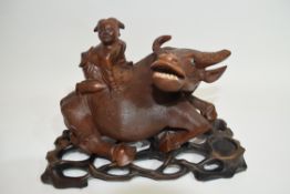 Oriental carving of a boy on a buffalo on wooden base, 20cm long