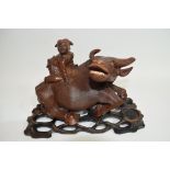 Oriental carving of a boy on a buffalo on wooden base, 20cm long
